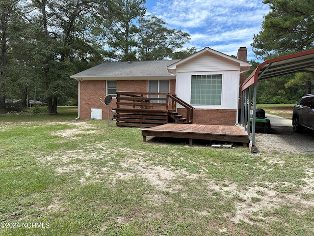 rear view of house with a yard, a deck, and a carport