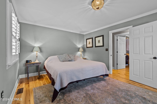 bedroom featuring wood-type flooring and crown molding