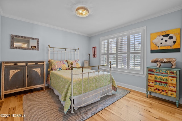 bedroom with ornamental molding and hardwood / wood-style floors