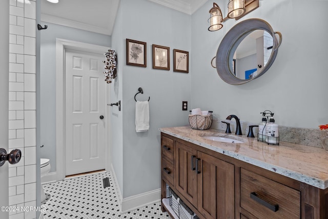 bathroom featuring tile patterned flooring, ornamental molding, vanity, and toilet