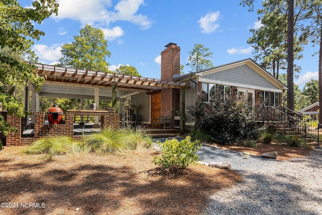 rear view of house featuring a pergola