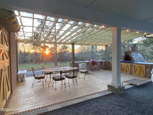 deck at dusk with an outdoor stone fireplace