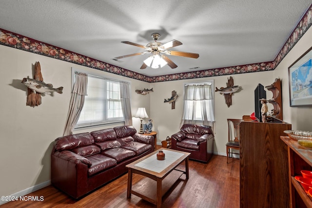 living room featuring dark wood-type flooring, a textured ceiling, and ceiling fan