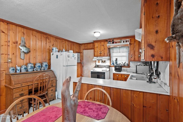 kitchen featuring white appliances, light hardwood / wood-style floors, sink, kitchen peninsula, and a textured ceiling