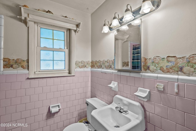 bathroom with tile walls, toilet, decorative backsplash, and sink