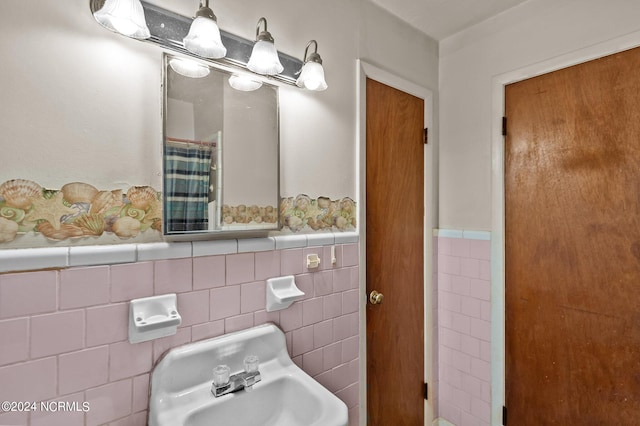 bathroom featuring tile walls, sink, and tasteful backsplash