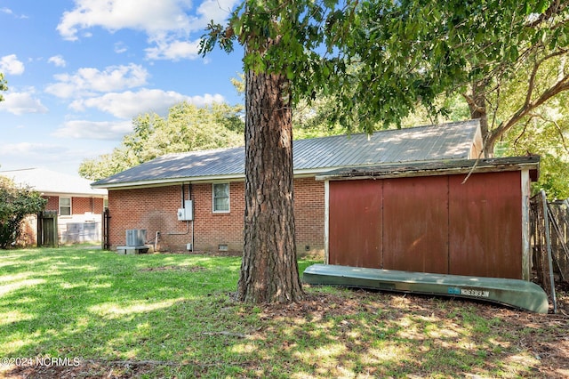 view of home's exterior with a yard and a storage shed