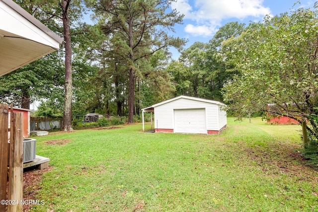 view of yard featuring a garage, an outdoor structure, and central AC