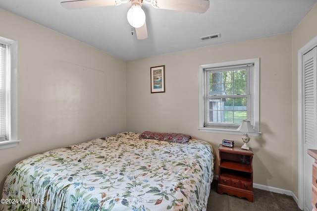 carpeted bedroom with ceiling fan and a closet