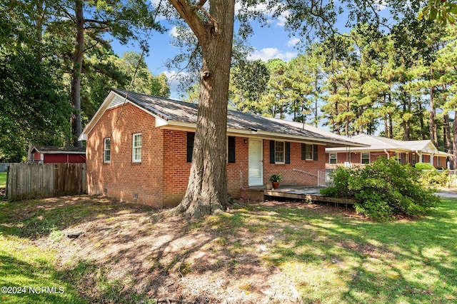 single story home featuring a deck and a front yard