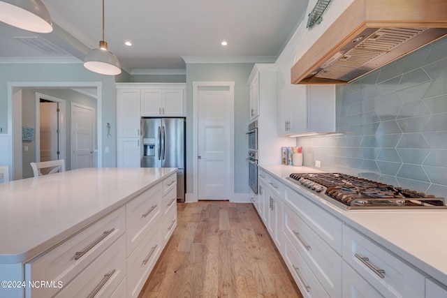 kitchen with custom range hood, crown molding, stainless steel appliances, light wood-type flooring, and white cabinets