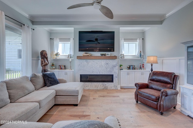 living room with crown molding, ceiling fan, and light hardwood / wood-style floors