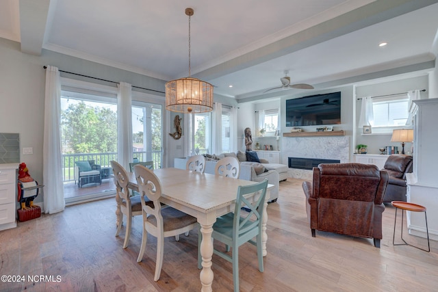 dining area with ceiling fan with notable chandelier, crown molding, and light hardwood / wood-style flooring