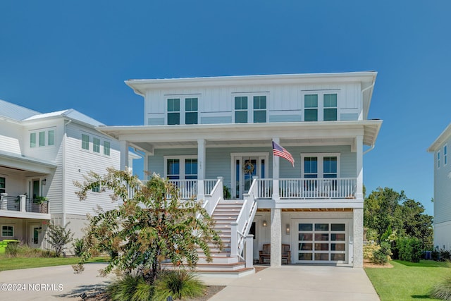 raised beach house with covered porch and a garage