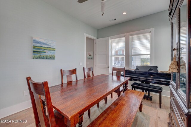 dining space with ceiling fan and light hardwood / wood-style flooring