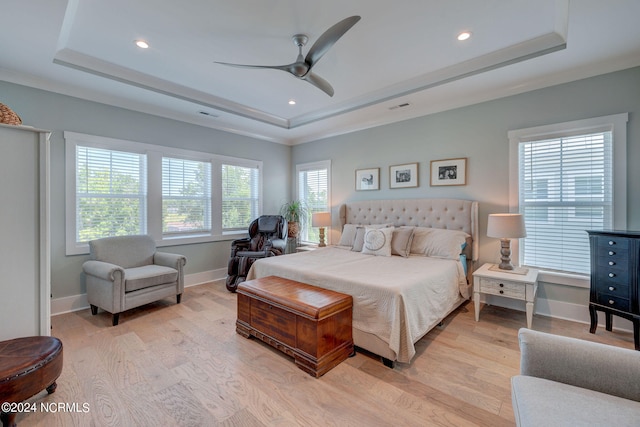 bedroom featuring a tray ceiling, crown molding, ceiling fan, and light hardwood / wood-style floors