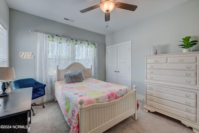 carpeted bedroom with ceiling fan and a closet