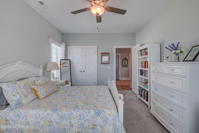 carpeted bedroom featuring ceiling fan and a closet