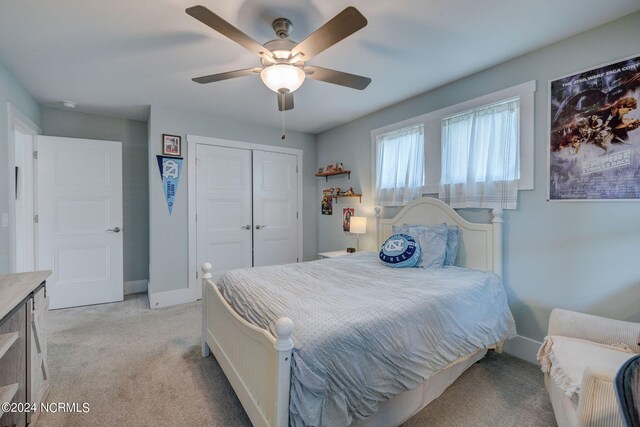 carpeted bedroom with ceiling fan and a closet