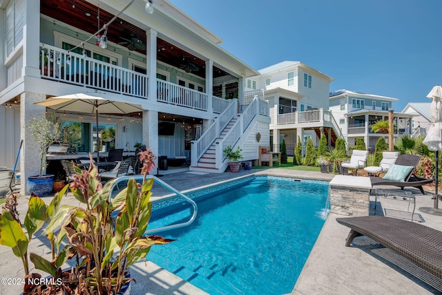 view of pool with pool water feature, ceiling fan, and a patio area