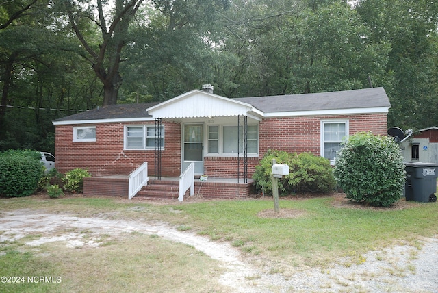 view of front of house featuring brick siding and a front yard