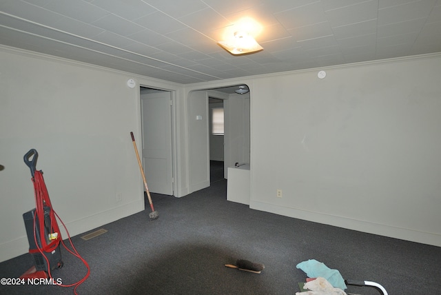 unfurnished room with carpet floors, visible vents, ornamental molding, and baseboards