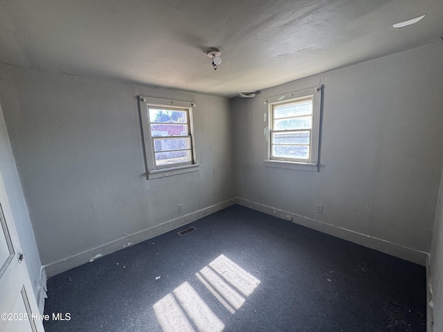 unfurnished room featuring visible vents and baseboards