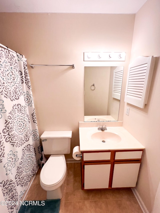 bathroom featuring vanity, toilet, walk in shower, and tile patterned flooring