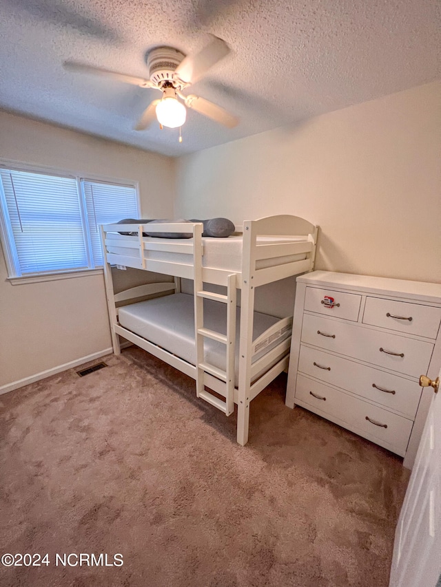 carpeted bedroom with a textured ceiling and ceiling fan