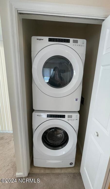 clothes washing area featuring stacked washer / drying machine