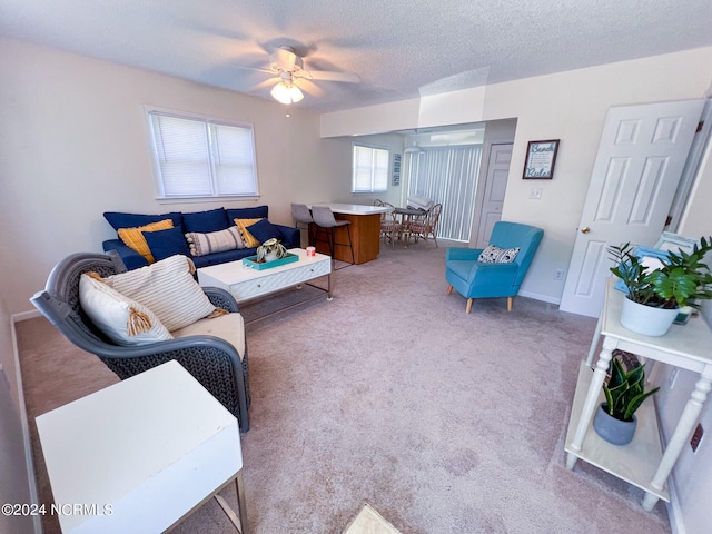 carpeted living room with a textured ceiling and ceiling fan