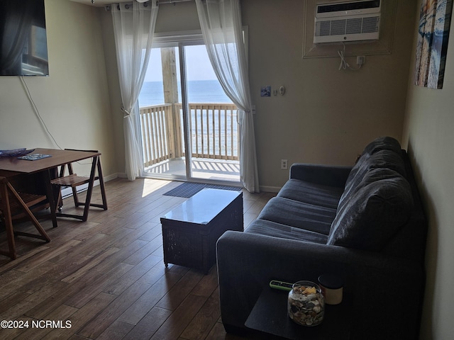 living room with a water view, a wall mounted air conditioner, and hardwood / wood-style floors