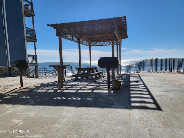 view of patio with a water view and a grill