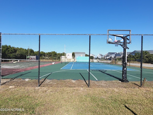 view of sport court featuring a yard