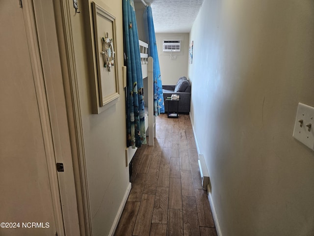 hallway with a wall mounted AC and a textured ceiling