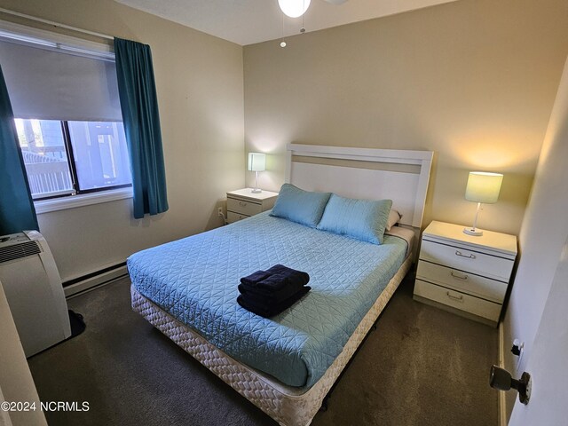 bedroom featuring a baseboard heating unit and dark carpet