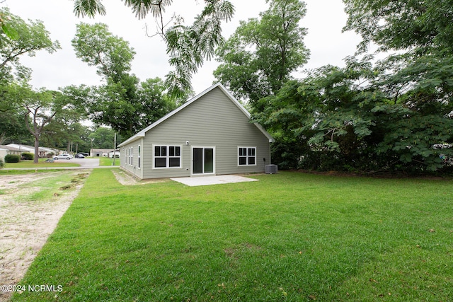 rear view of property featuring a patio area, a yard, and central AC