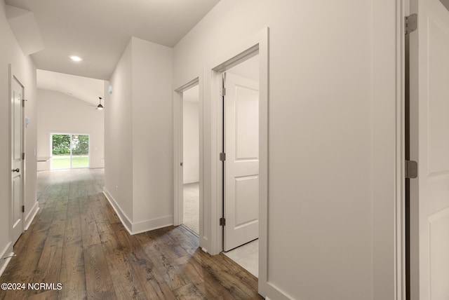 corridor featuring vaulted ceiling and dark hardwood / wood-style floors