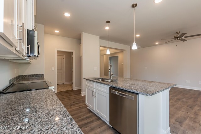 kitchen featuring dark stone counters, white cabinetry, a center island with sink, and dark wood-type flooring