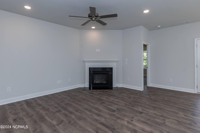 unfurnished living room featuring ceiling fan and dark wood-type flooring