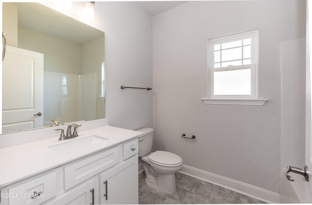 bathroom with vanity, toilet, and a shower