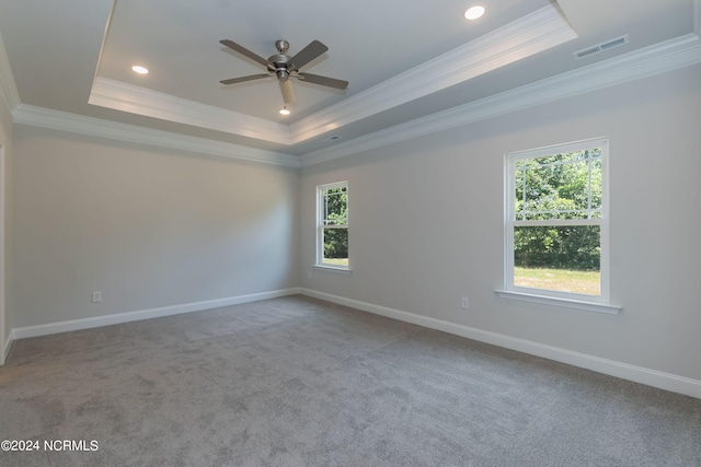 carpeted spare room with a tray ceiling, ceiling fan, and ornamental molding