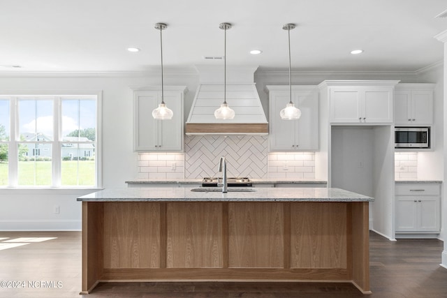 kitchen with a center island with sink, white cabinets, light stone counters, and dark wood-type flooring