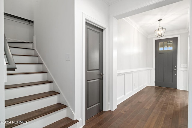 141 Sycamore Lakes Dr, Wallace, NC 28466 - entrance foyer with a chandelier, ornamental molding, stairs, dark wood finished floors, and a wainscoted wall