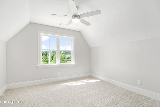 additional living space featuring light colored carpet, vaulted ceiling, and ceiling fan