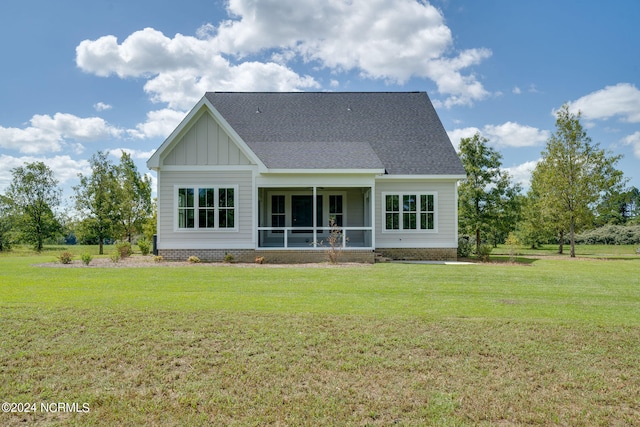 rear view of house with a sunroom and a lawn