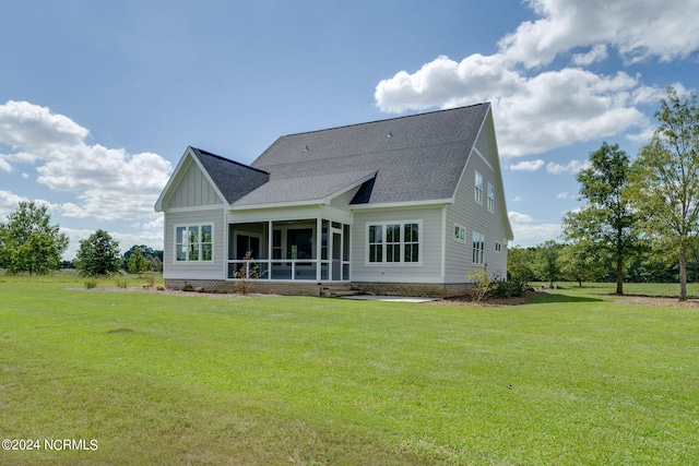 rear view of house with a sunroom and a yard