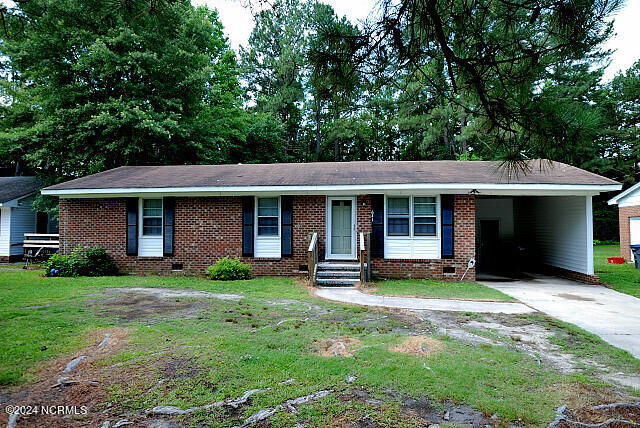 ranch-style house featuring a front yard and a carport