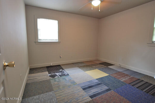 carpeted empty room featuring ceiling fan