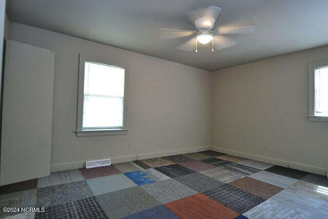 empty room featuring plenty of natural light and ceiling fan